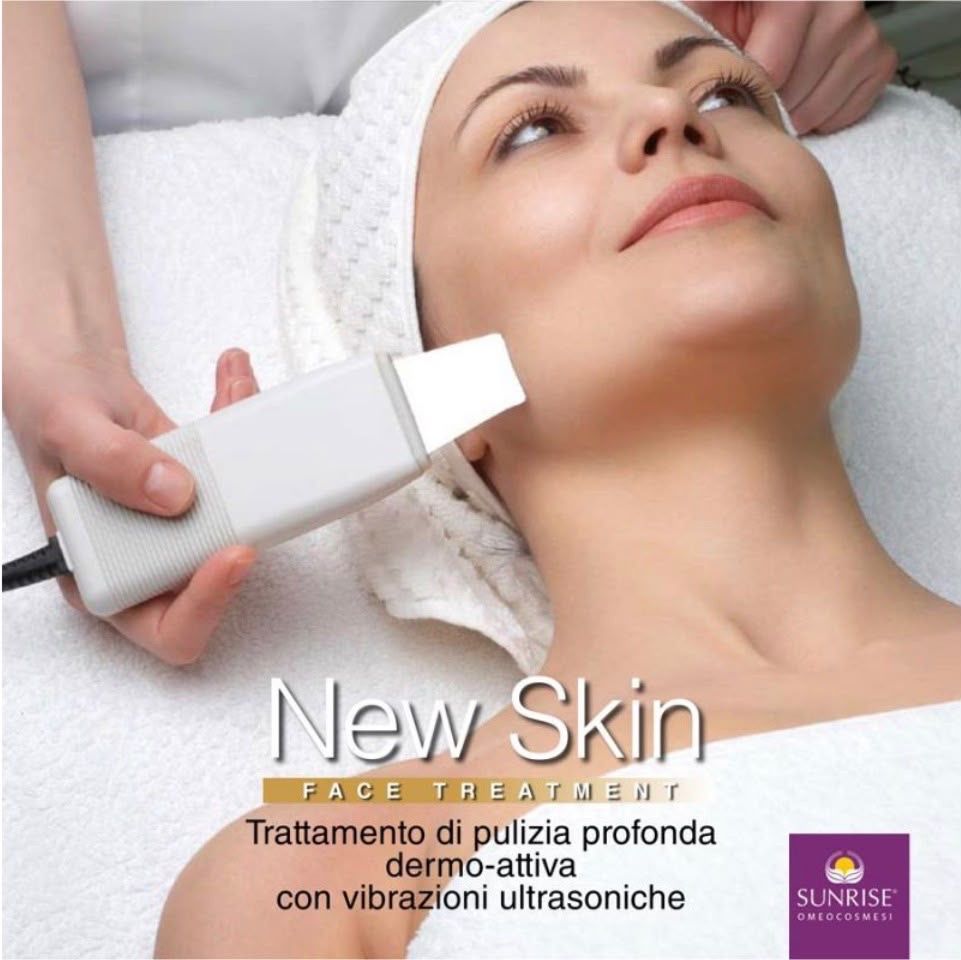 La spatola a ultrasuoni sul collo di una cliente distesa; sulla foto la scritta «New Skin face treatment — trattamento di pulizia profonda dermo-attiva con vibrazioni ultrasoniche»