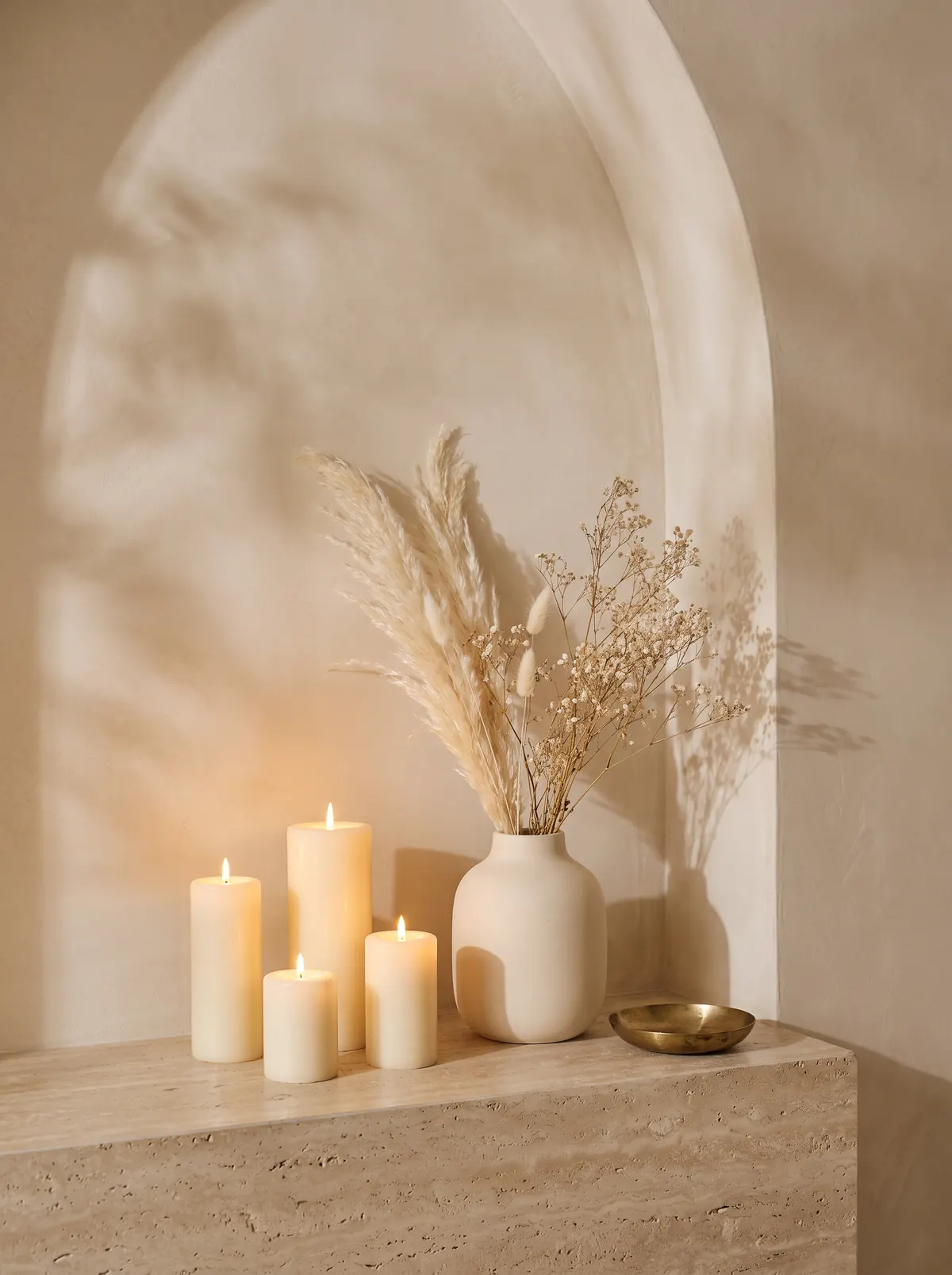 Candele accese e un vaso con pampas e fiori secchi in una nicchia ad arco (immagine provvisoria)